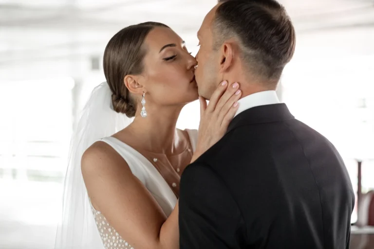 Nuotaka bučiuoja jaunikį – artimas vestuvių bučinio kadras, Birute Bras Photography