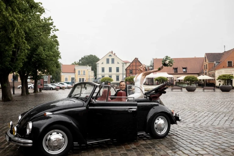 Jaunavedžiai vintažiniame VW Beetle kabriolete senojo miesto aikštėje – vestuvių nuotrauka, Birute Bras Photography