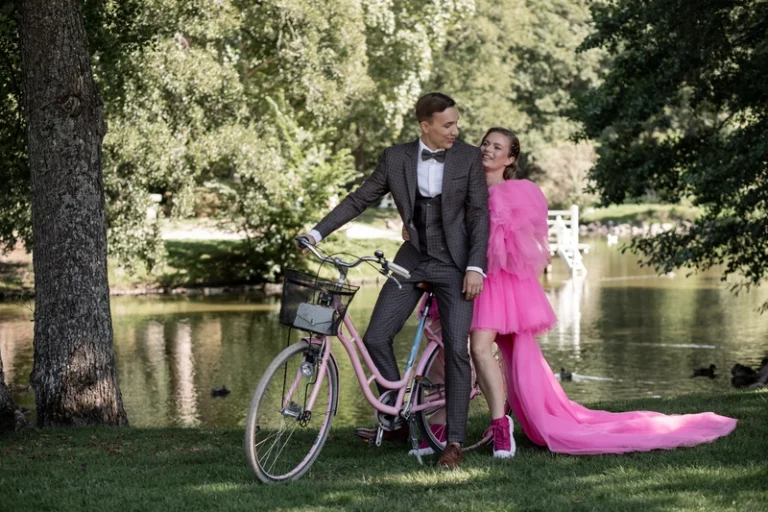 Pora su dviračiu prie ežero parke, nuotaka rožinėje suknelėje – romantiška vestuvių fotosesija, Birute Bras Photography